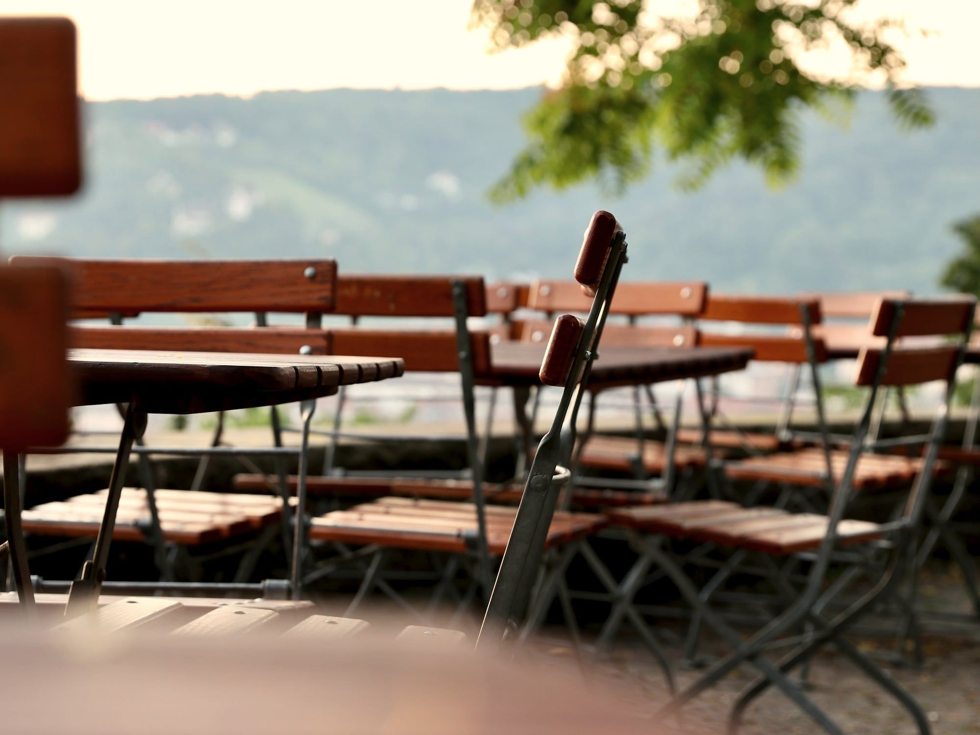 Klappstühle und Holztische in einem Biergarten